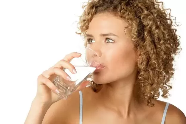 लड़की आलसी लोगों के लिए आहार का पालन करती है, खाने से पहले एक गिलास पानी पीती है